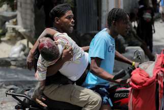 People take a wounded man to a hospital in Port-au-Prince, Haiti, Aug. 15, 2023, after gangs took over their neighborhood Carrefour-Feuilles. Vatican News reported Jan. 19, 2024, that armed men in Port-au-Prince took over a bus and kidnapped at least six nuns and others who were on the bus. The gunmen, who drove off with them to an unknown destination, were not immediately identified but authorities suspected they were gang members.