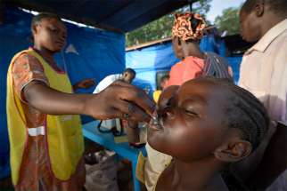 A child swallows an oral cholera vaccine at a displaced persons camp at the Holy Family Catholic Church in Wau, South Sudan, April 17.