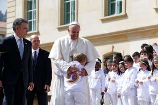 Pope Francis greets a child while meeting with Colombian President Juan Manuel Santos and other government authorities in the courtyard of the presidential palace in Bogota, Colombia, Sept. 7. 
