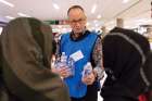 CSS&#039; Dr. Troy Davies handing out watter bottles to newcomers at Edmonton International Airport.