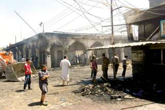 Iraqis inspect the scene of a July 8 suicide bomb attack outside Imam Mohammed shrine near Baghdad. 