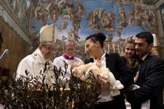 Pope Francis baptizes one of 28 babies in the Sistine Chapel at the Vatican Jan. 8.
