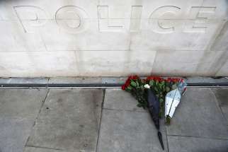 Flowers sit outside New Scotland Yard March 23, the morning after an attack by a man driving a car and wielding a knife left five people dead and dozens injured in London.