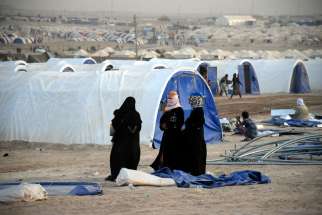 Displaced Iraqi women wait for their tent to be built June 21 at a refugee camp in Fallujah. Vatican observer to U.N. agencies in Geneva, Archbishop Ivan Jurkovic, says the world has a duty to protect refugees.