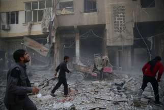 en inspect a damaged site after an Oct. 26 airstrike on the rebel-held besieged region of Douma in Damascus, Syria.