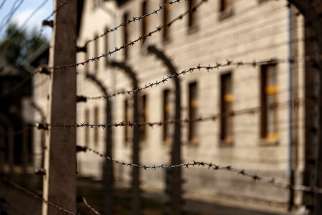 Lines of barbed-wire fencing enclose the Auschwitz-Birkenau Nazi death camp in Oswiecim, Poland, in this Sept. 4, 2015, file photo.
