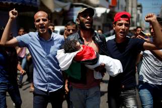 Mourners carry the body of 8-month-old Palestinian Laila al-Ghandour, who died after inhaling tear gas at the Israel-Gaza border during a May 15 protest against the U.S embassy move to Jerusalem.