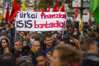 People hold a banner during an Oct. 12 demonstration in Berlin against the Islamic State militant group, known as ISIS, and its insurgent attacks on the Syrian Kurdish town of Kobani.