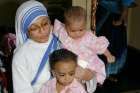 A member of the Missionaries of Charity holds orphan children in 2007 at a center in Kolkata, India. The Missionaries of Charity will close their adoption centers in India, citing new regulations that would allow nontraditional families to adopt children, reported ucanews.com. 