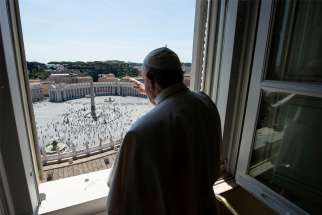 Pope Francis waves as he looks out on St. Peter&#039;s Square after leading the &quot;Regina Coeli&quot; from his library in the Apostolic Palace at the Vatican May 24, 2020. It was the first time the public was allowed in the square given the ongoing easing of restrictions during the coronavirus pandemic.