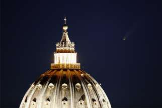 The comet &quot;Neowise&quot; is seen in the sky behind the dome of St. Peter&#039;s Basilica in Rome July 13, 2020.