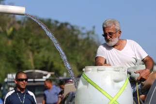 A man fills a plastic drum with spring water from a mountain in Utuado, Puerto Rico, Oct. 21, 2019. Access to clean, fresh water is a fundamental human right that must be defended, especially in poor areas where men, women and children are suffering the deadly effects of climate change, Pope Francis said. 