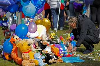 A woman looks at flowers, candles and toys left as a memorial to Alfie Evans in Liverpool, England, April 28. The 23-month-year-old died April 28 from complications of a degenerative brain condition.