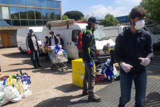 Volunteers for a local association, &quot;Cittadini del Mondo,&quot; work to bring needed assistance to refugees and others living in an occupied building in Rome. The association is concerned 50 occupants recently testing positive for coronavirus may signal more cases to come.