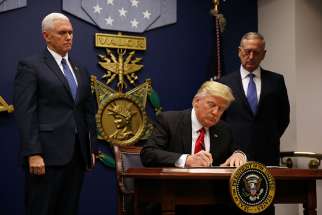 U.S. President Donald Trump signs a revised executive order for a U.S. travel ban March 6 at the Pentagon in Arlington, Va. The executive order temporarily bans refugees from certain majority-Muslim countries, and now excludes Iraq.