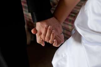  A groom and bride hold hands on their wedding day. 