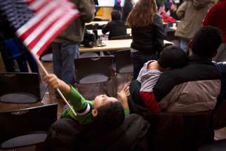 A boy waves the American flag Nov. 20, 2014 at CASA de Maryland&#039;s Multicultural Center in Hyattsville, Md., after hearing President Barack Obama&#039;s national address on immigration. A U.S. federal judge ordered the Obama administration to release the immigrant mothers and children locked in detention centres by Oct. 23, 2015.