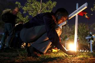 A woman lights a candle on a wooden cross after an April 14 memorial concert in Nairobi, Kenya, for the 147 people killed in an attack on Garissa University College. Pope Francis is calling for perpetrators of extremist violence in Kenya &quot;to come to their senses and seek mercy.&quot;