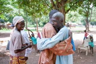 Villagers embrace in 2014 on the grounds of the Monastery of Boy Rabe in Bangui, Central African Republic.