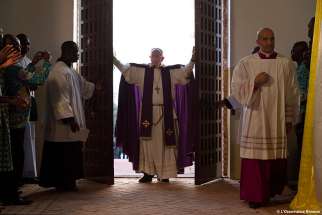 Pope Francis walks through the Holy Door after opening it to begin the Holy Year of Mercy at the start of a Mass with priests, religious, catechists and youths at the cathedral in Bangui, Central African Republic, Nov. 29.