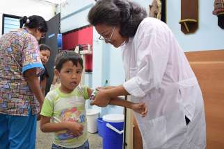 A doctor measures the arms of a child attending the local SAMAN nutrition clinic, a partnership between sisters of Our Lady of the Immaculate Conception of Castres and Caritas Internationalis.