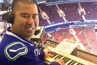 Catholic sports fan Clayton Imoo, pictured playing the organ before a Canucks game in 2016, sees his video blogs, sports commentaries and viral music parodies as an extension of his ministry. 