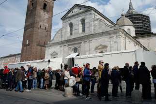 People wait in line outside the Cathedral of St. John the Baptist before the opening of the public exposition of the Shroud of Turin in Turin, Italy, April 19. The shroud, believed by many to be the burial cloth of Jesus, is on display from April 19 through June 24, 2015. 