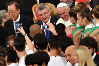Pope Francis is seen with U.N. Secretary-General Ban Ki-moon, left, and Thomas Bach, president of the International Olympic Committee, during the opening ceremony of a world conference on faith and sport Oct. 5 in the Vatican&#039;s Paul VI audience hall.