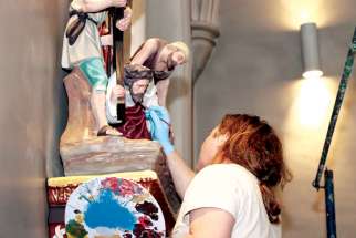 An artist puts his brush to work in restoring the statues of the cathedral in St. Catharines, Ont. The church celebrates 175 years in 2020.