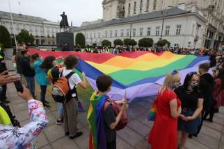 Demonstrators hold a giant rainbow flag during a protest against hatred toward LGBT people in Warsaw, Poland, Aug. 30, 2020.
