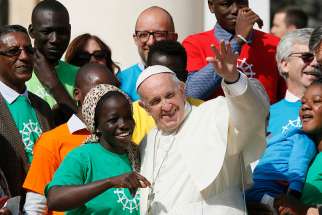 Pope Francis greets immigrants and representatives of Caritas Internationalis during his general audience in St. Peter&#039;s Square at the Vatican Sept. 27. Caritas Internationalis was kicking off its &quot;Share the Journey&quot; campaign in support of immigrants. 