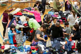 Evacuees from the Fort McMurray wildfires look through donated goods and clothing May 5 at the Bold Center in Lac la Biche, Alberta. Pope Francis has added his name to the list of people offering condolences to those affected by the massive forest fire that has led to the evacuation of Fort McMurray.