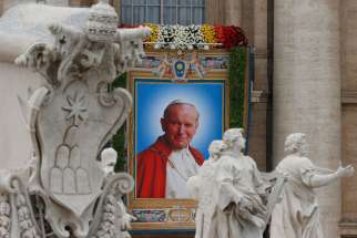 A banner depicting St. John Paul II hangs from the facade of St. Peter&#039;s Basilica at the Vatican April 27.