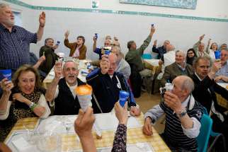 People raise their ice cream cones donated by Pope Francis as they toast the pope at a Sant&#039;Egidio soup kitchen in Rome April 23. In honor of his name day, the feast of St. George, the pope donated 3,000 servings of ice cream to soup kitchens and homeless shelters around Rome. 