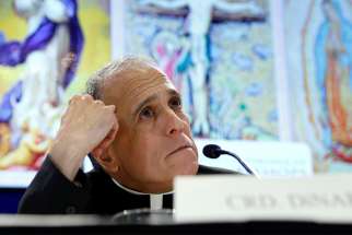 Cardinal Daniel DiNardo, president of the U.S. Conference of Catholic Bishops, looks up while holding a press conference Nov. 12 at the bishops&#039; general assembly in Baltimore. 