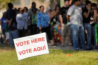 A sign in English and Spanish is seen as people wait to vote in 2012 outside a polling place in Kissimmee, Fla. A Pew Research Center poll released Oct. 10 shows Hispanic Americans give nearly a 5-1 edge to Democrats over Republicans as the party they feel is more concerned for them.