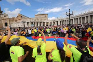 Pilgrims hold a large Colombian flag as Pope Francis leads the Angelus in St. Peter&#039;s Square Sept. 17 at the Vatican. 