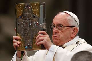 Pope Francis raises the Book of the Gospels as he celebrates Holy Thursday chrism Mass in St. Peter&#039;s Basilica at the Vatican April 13.