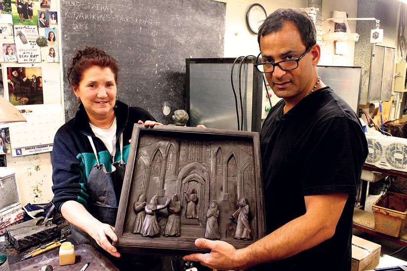 Sculptor Farhad Nargol O’Neil and Holly Atkinson display one of 20 panels for the new bronze doors. (Photo courtesy of Concrete Pictures Inc.)
