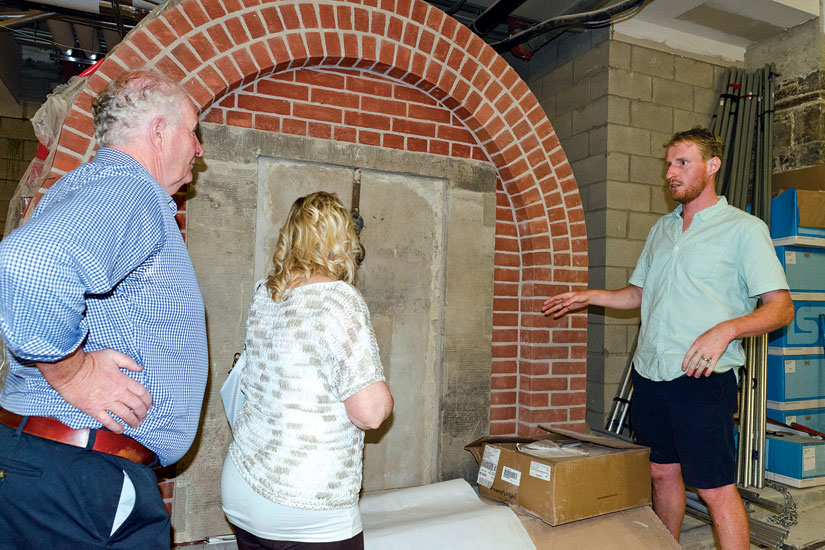 Tomas Nugent shows off his handiwork in the crypts to his parents, Michael and Kathleen. Nugent is carrying on the work of the Irish immigrants who built St. Michael’s in the 1840s. (Photo by Evan Boudreau)