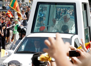 Pope Benedict XVI waves to the crowd from his popemobile after arriving in Madrid Aug. 18. 