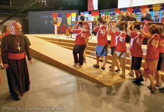 Ottawa Archbishop Terrence Prendergast follows a group of youth on stage as they carry the World Youth Day cross from Toronto's time as host in 2002. On stage, a group of bishops look on, including Edmonton Archbishop Richard Smith.