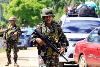 Philippine government troops stand guard May 24 at a checkpoint along a main highway in Lanao del Norte province. Residents started to evacuate the town of Marawi after President Rodrigo Duterte imposed martial law across the entire Muslim-majority region of Mindanao.