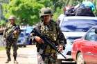 Philippine government troops stand guard May 24 at a checkpoint along a main highway in Lanao del Norte province. Residents started to evacuate the town of Marawi after President Rodrigo Duterte imposed martial law across the entire Muslim-majority region of Mindanao.