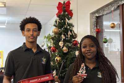 Grade 11 student Christian Teklu holds a red wagon, the namesake of the campaign next to Grade 12 student Brenda Obaseki. Both students have participated in multiple red wagon campaigns during their time at Archbishop Denis O’Connor Catholic High School.