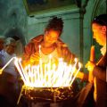 Pilgrims light prayer candles in the Church of the Holy Sepulchre.
