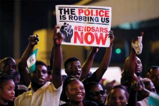 A demonstrator holds a sign during a protest in Lagos, Nigeria, Oct. 17 over alleged police brutality. Several Nigerian bishops have criticized police attacks that have left at least 12 protesters dead and hundreds injured. Emannuel Adegboyega, left, a Toronto high school student originally from Nigeria, implores Canadians to not take their freedom for granted.