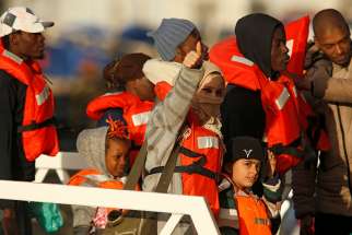 Migrants who were stranded on the nongovernmental organization migrant rescue ships Sea-Watch 3 and Professor Albrecht Penck disembark Jan. 9 from an Armed Forces of Malta patrol boat at its base in Valletta. Pope Francis issued a plea Jan. 6 to European governments to work together to find a way to assist the migrants.