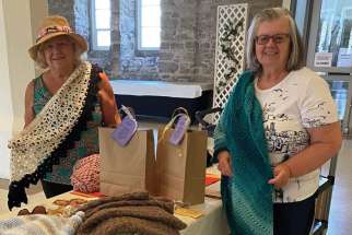Olga Ciaravella, left, and Janette Castellan show off some of the prayer shawls they have crocheted as part of a prayer shawl ministry in Guelph, Ont.