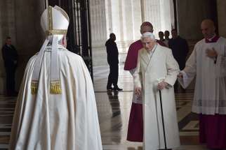 Retired Pope Benedict XVI prepares to greet Pope Francis during the opening of the Holy Door of St. Peter&#039;s Basilica at the Vatican in this Dec. 8, 2015, file photo.